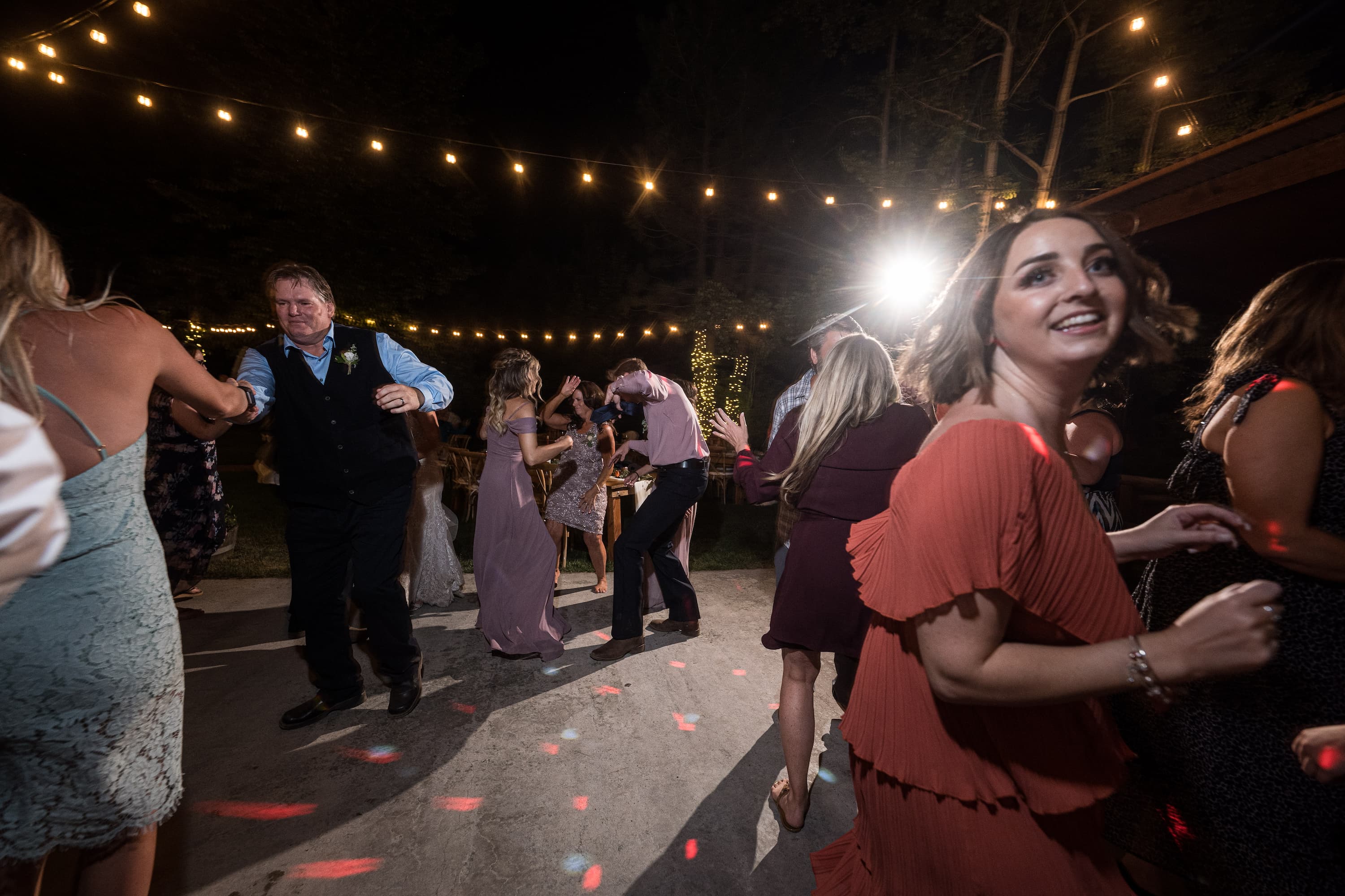 Correen and Kellen's guests dancing under string lights