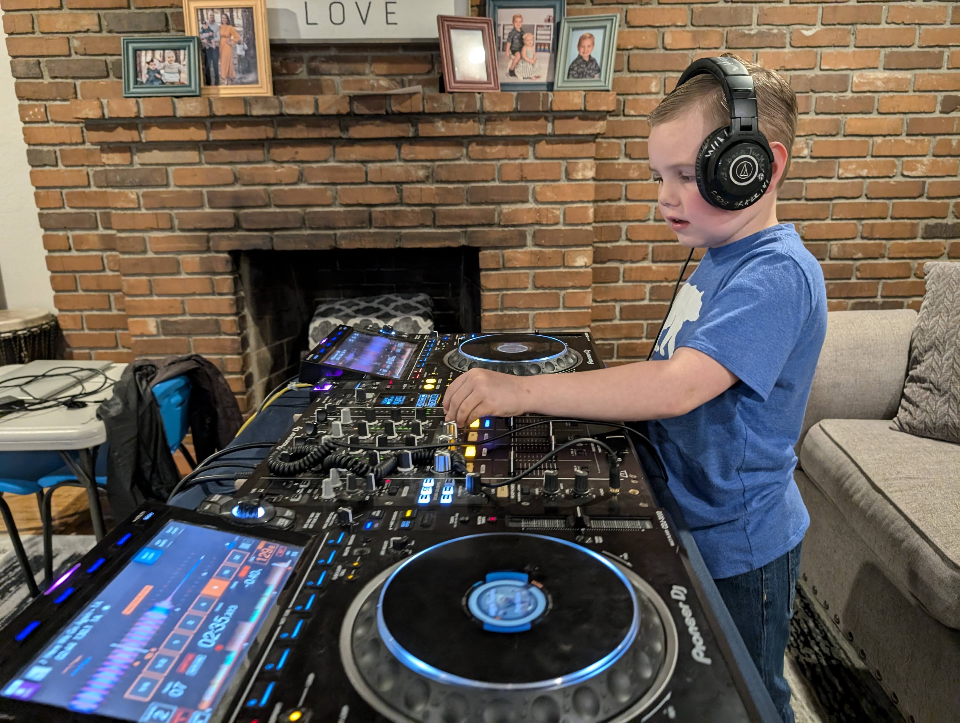 Young DJ student Deacan mixing on Pioneer DJ decks at home, wearing headphones