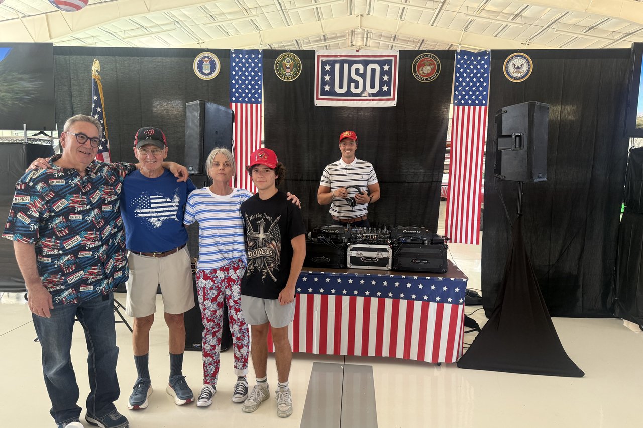 Guests posing in front of the USO stage and DJ booth