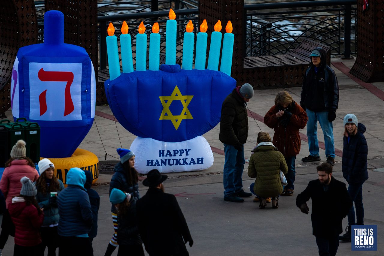 Families by the giant dreidel and menorah inflatables in City Plaza