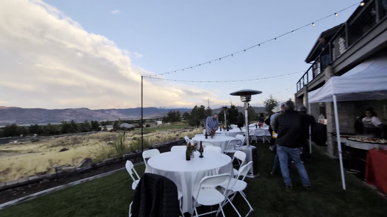 Round tables, string lights and the paella tent on the lawn at golden hour at John’s 50th birthday in ArrowCreek