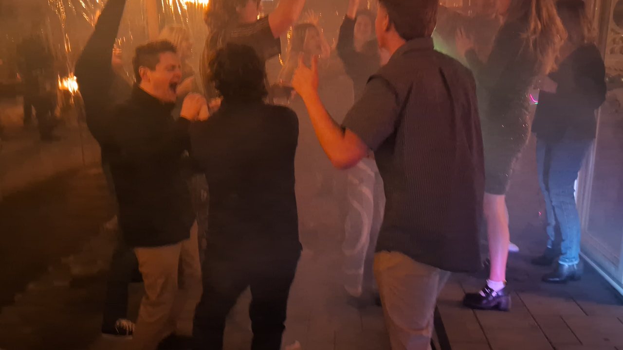 Guests dancing with their hands up in the fog at Niki’s 55th birthday party in Reno