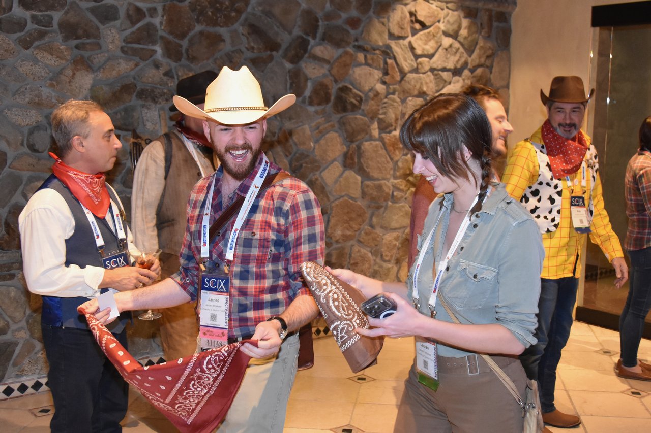 Guests in cowboy hats and plaid picking out bandanas at the SciX Gala welcome