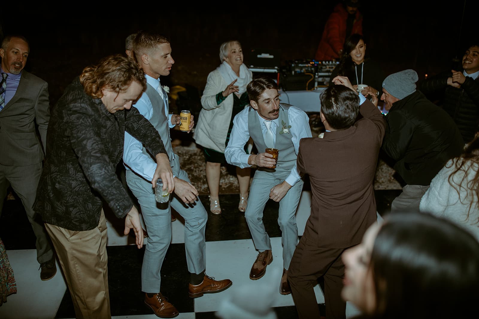 Groomsmen and guests dancing on a checkered dance floor