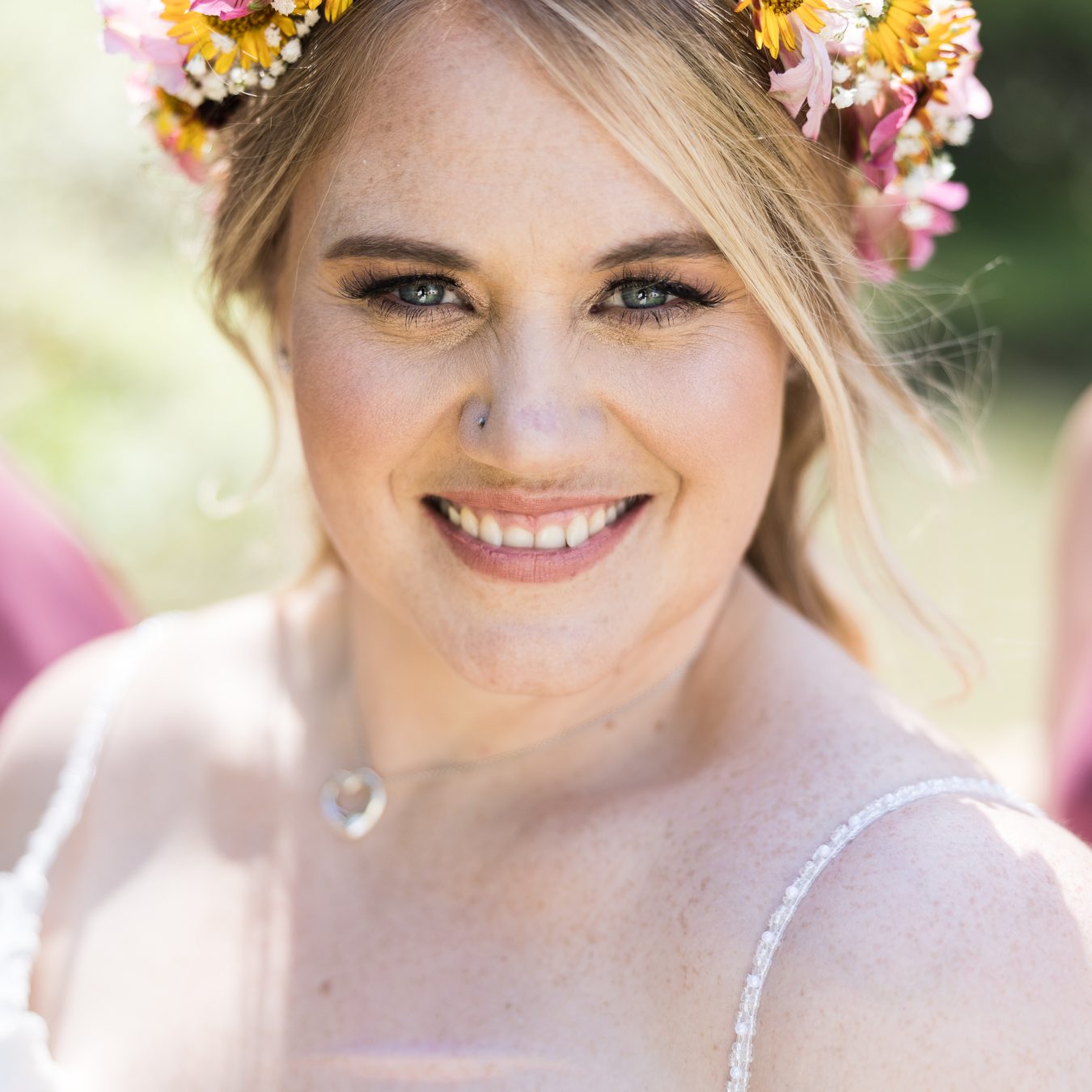 Abney smiles straight into the camera in a close portrait, wearing her flower crown