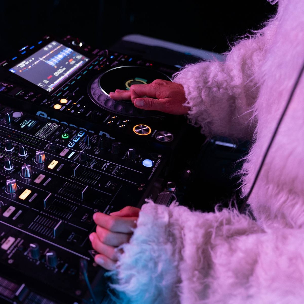 A DJ in a white bunny suit works the CDJ 3000 and mixer at CMYK Festival in Reno