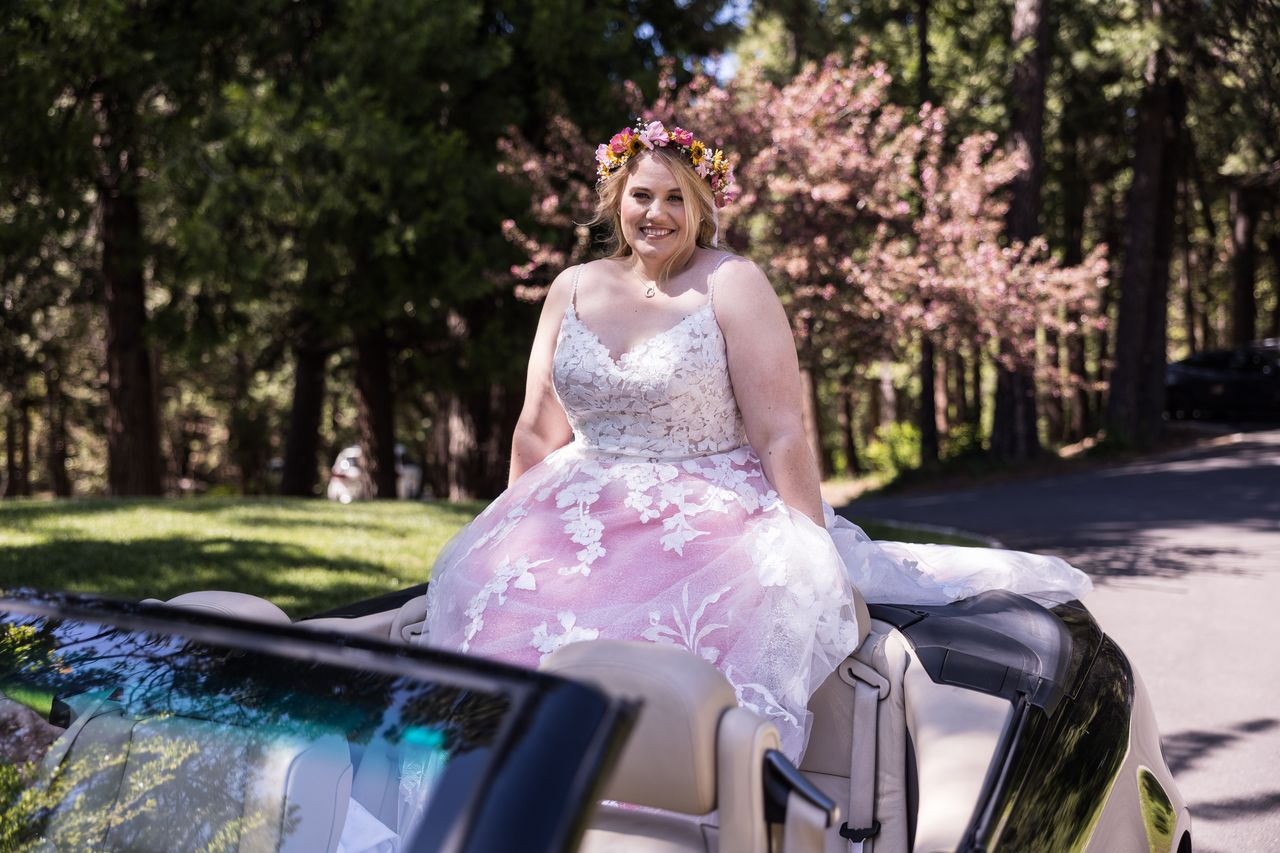 Abney smiles at the camera from the back of a convertible on her way to the ceremony