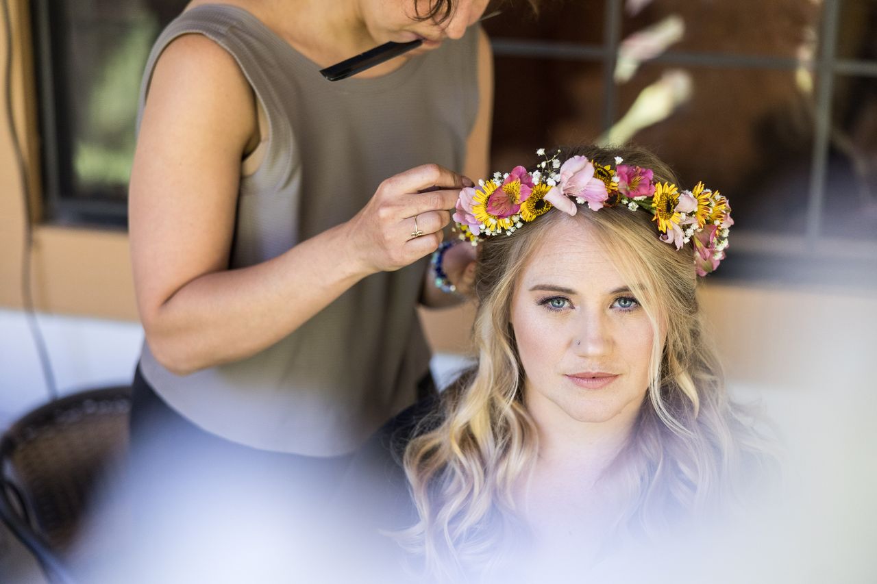 Abney looks into the camera as her flower crown is set in place