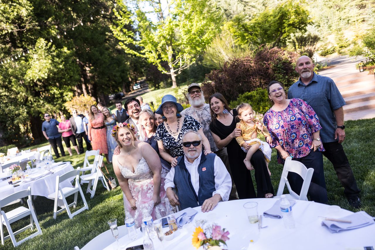 Guests stand together at their table for a photo with Abney and Chris
