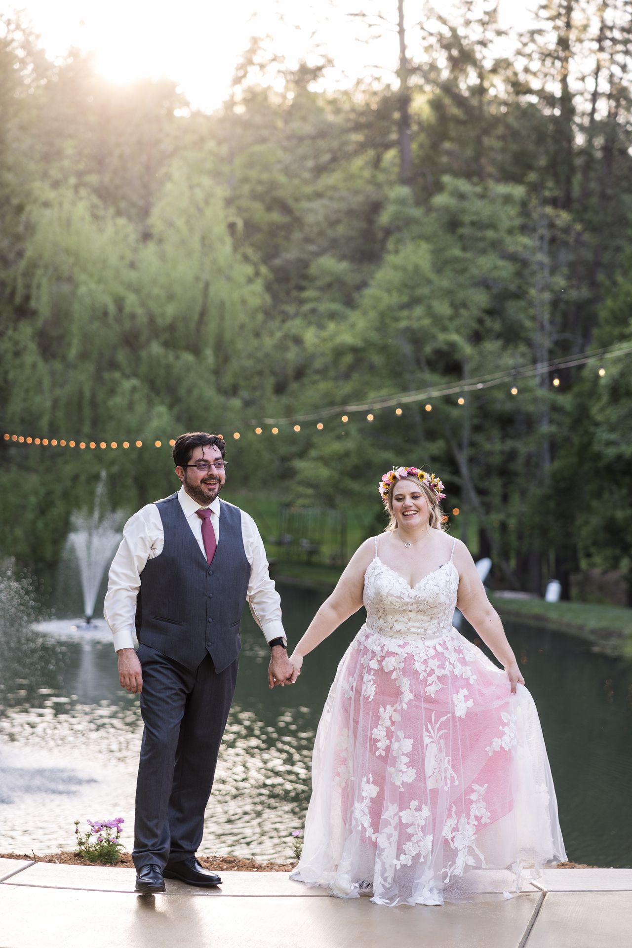 Abney and Chris walk hand in hand beside the pond, both laughing