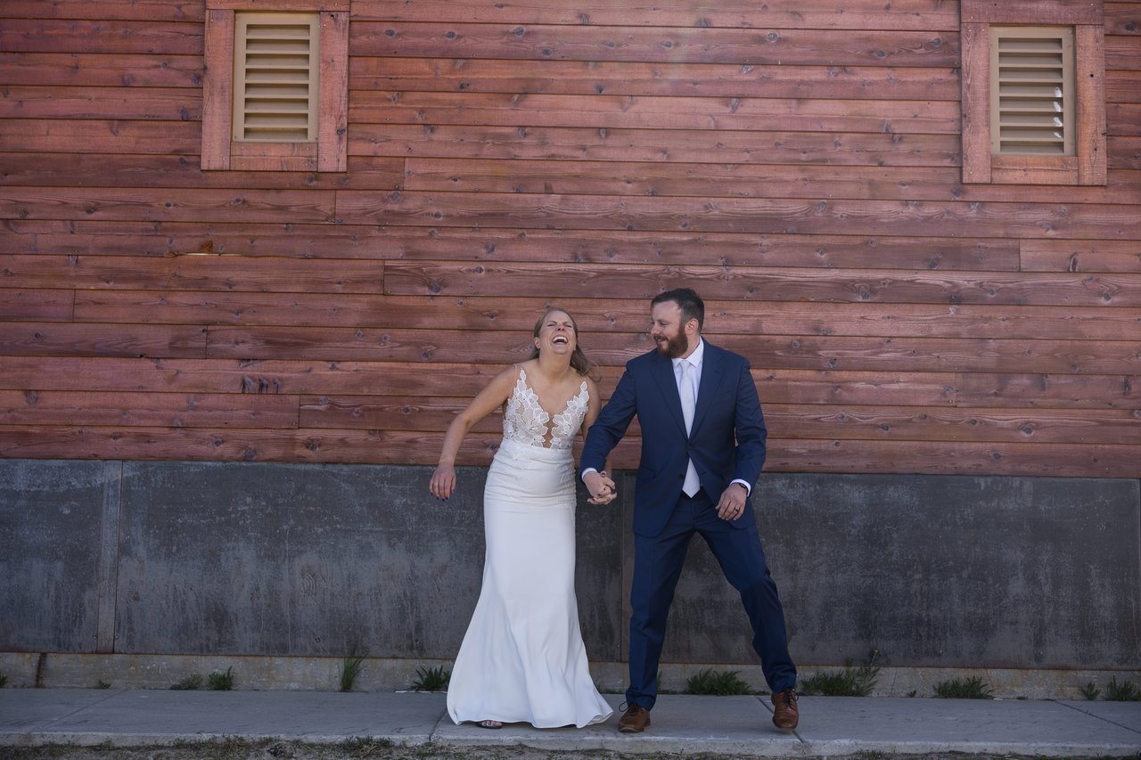 Ali and Robert dance in front of a huge red barn wall