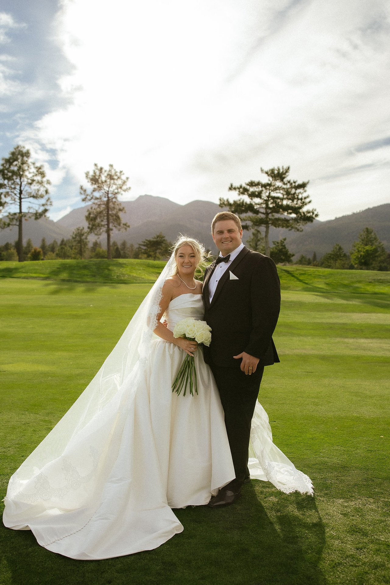 Ally and Drew on the fairway with the mountains behind them