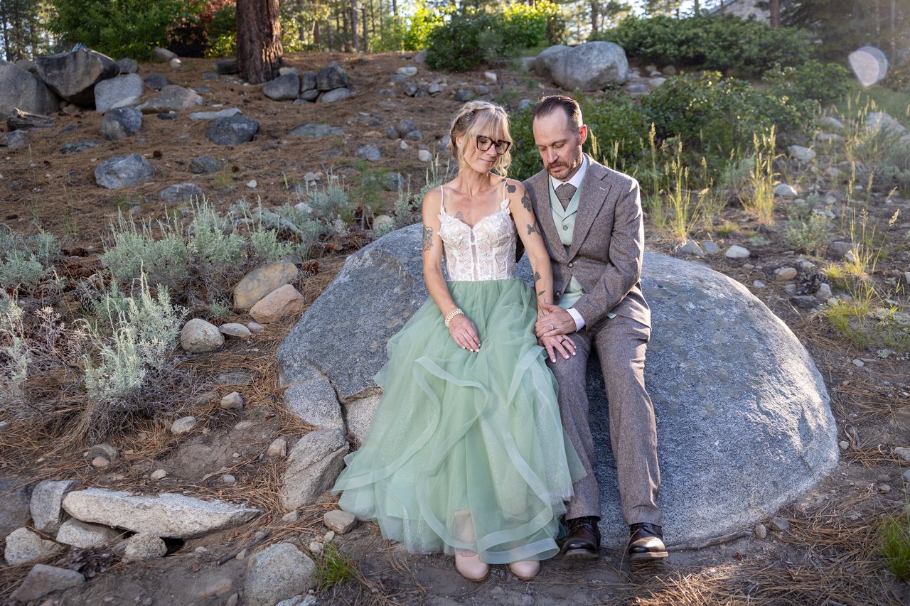 Amy and Justin sit on the boulder among the sagebrush
