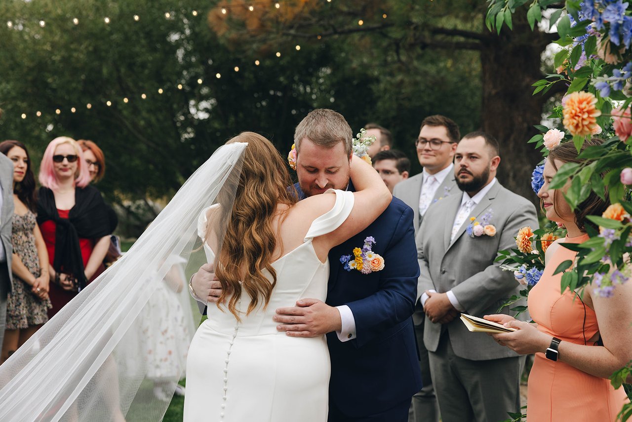 Autumn and Peter hug at the altar as the ceremony begins