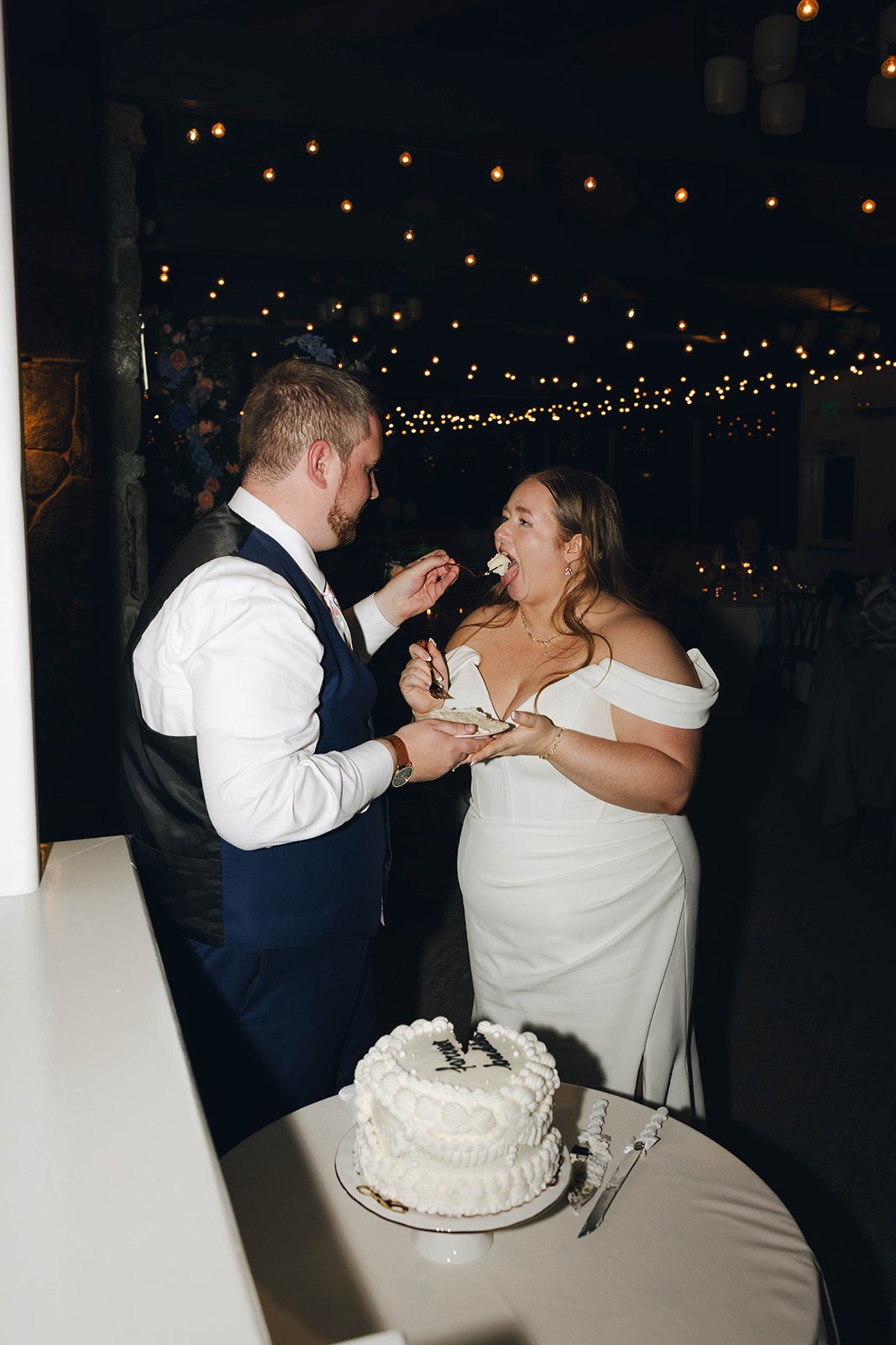 Autumn laughs as Peter feeds her a bite of wedding cake