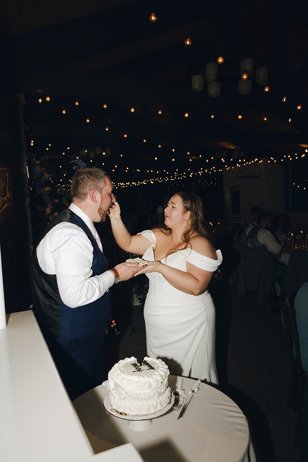 Autumn dabs frosting on Peter's face beside their wedding cake
