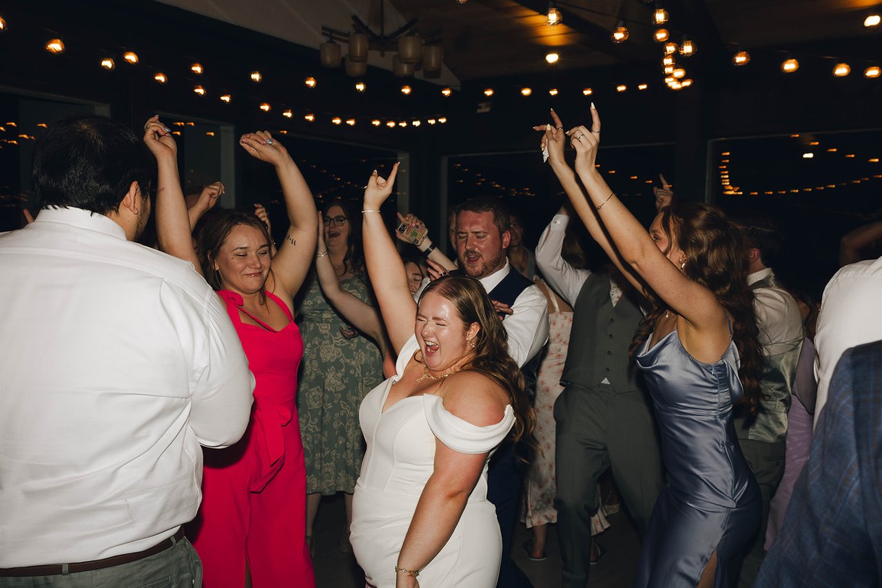 A packed dance floor with hands in the air and Autumn laughing in the middle