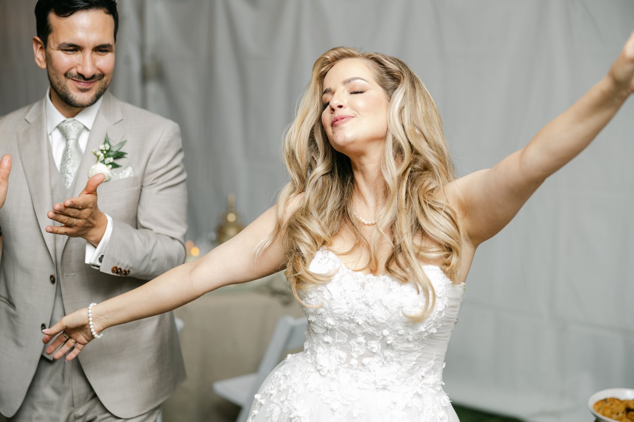 Britt dances with her arms wide as Chris claps beside her