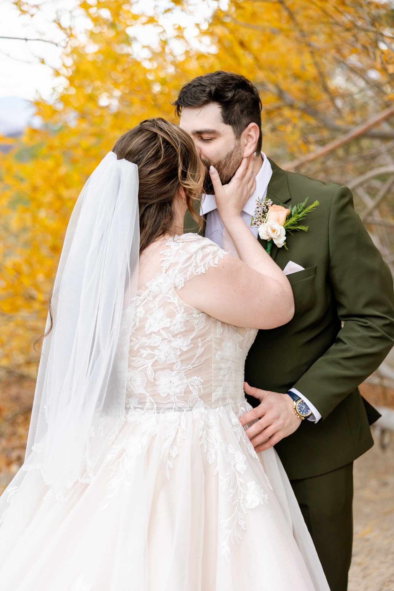 Danielle and Brandon kiss under the golden aspens, her hand on his face