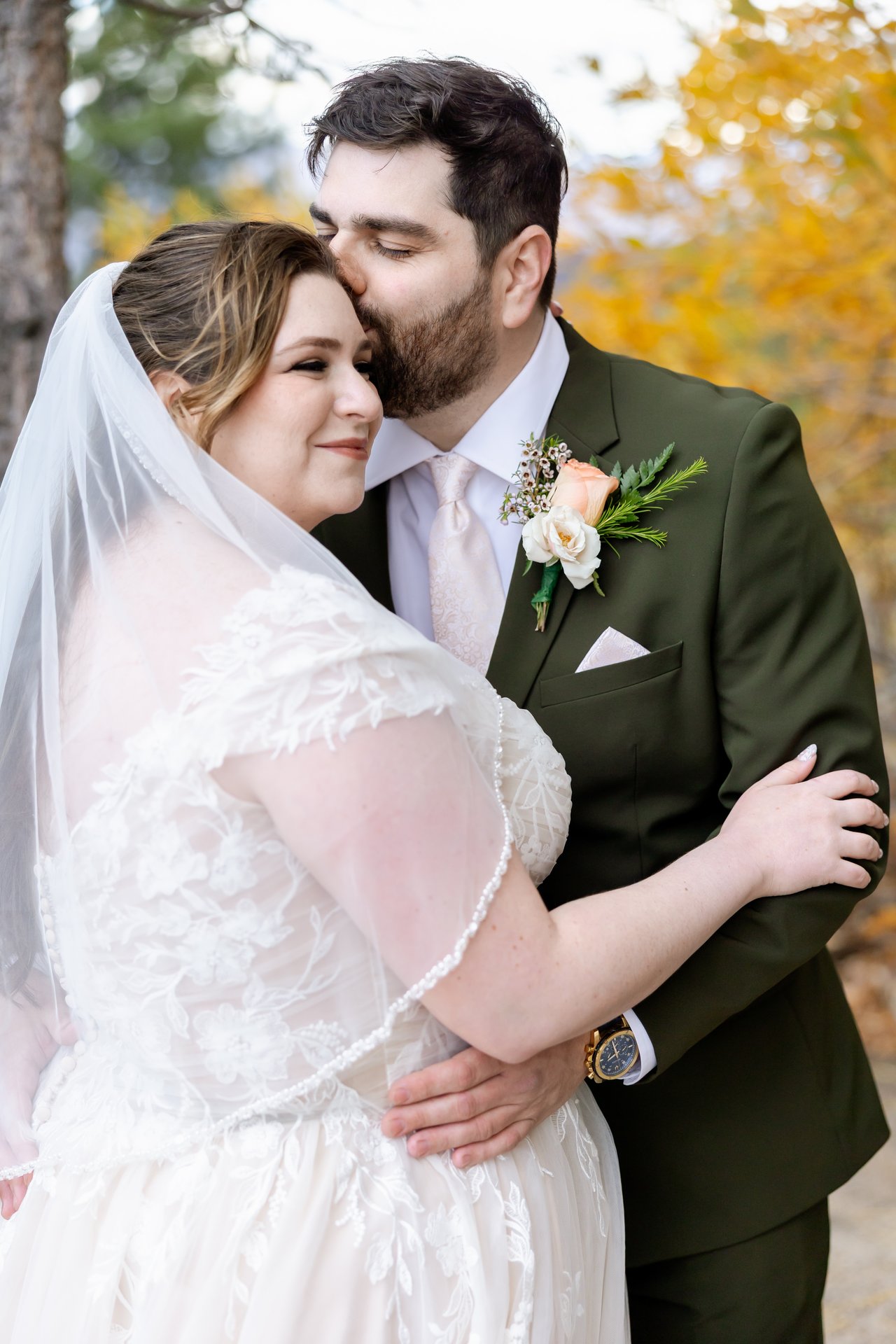 Brandon kisses Danielle's forehead as she smiles with her eyes closed