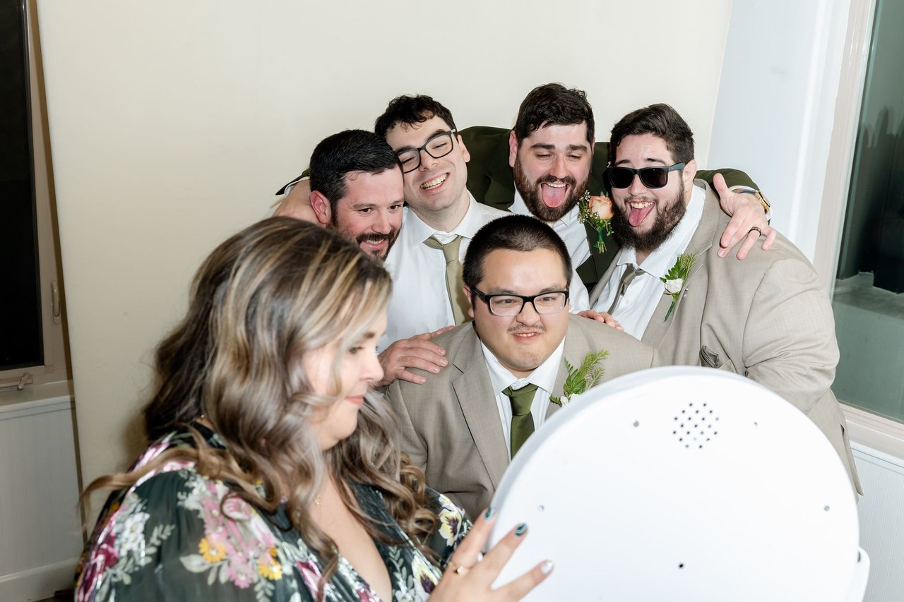 Groomsmen pile in for a photo booth picture