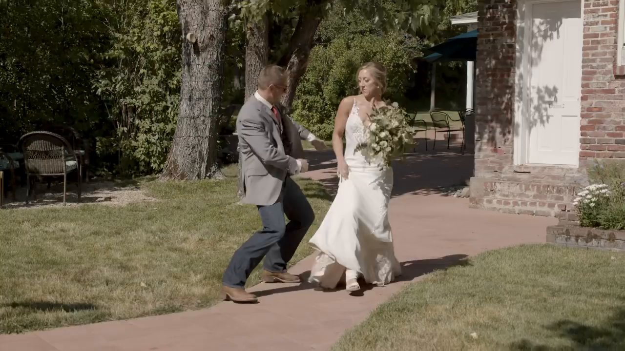 Scott and Danielle dance up the brick path into the reception