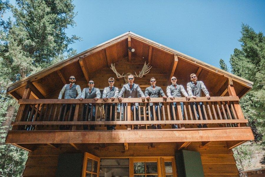 Scott and his groomsmen lean on the cabin balcony under the antlers, photo by Composing Reality Photography