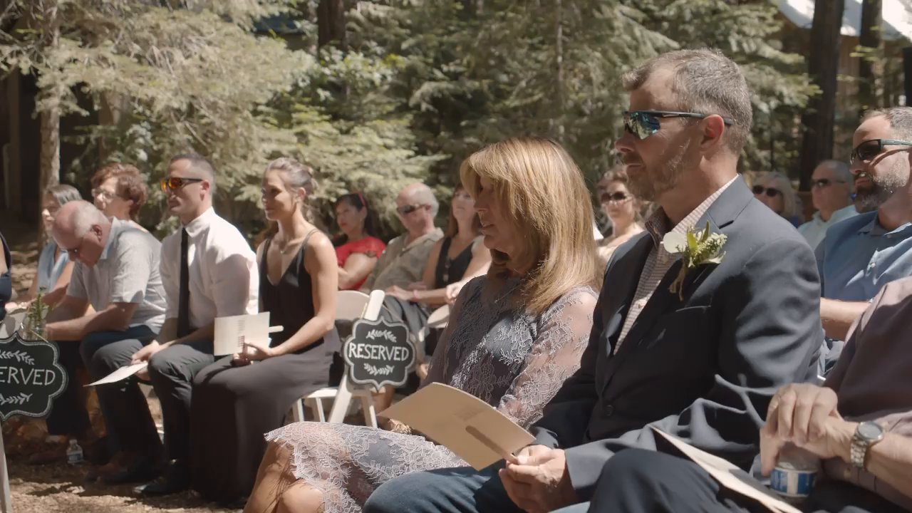 Guests smile from their seats in the forest before the ceremony