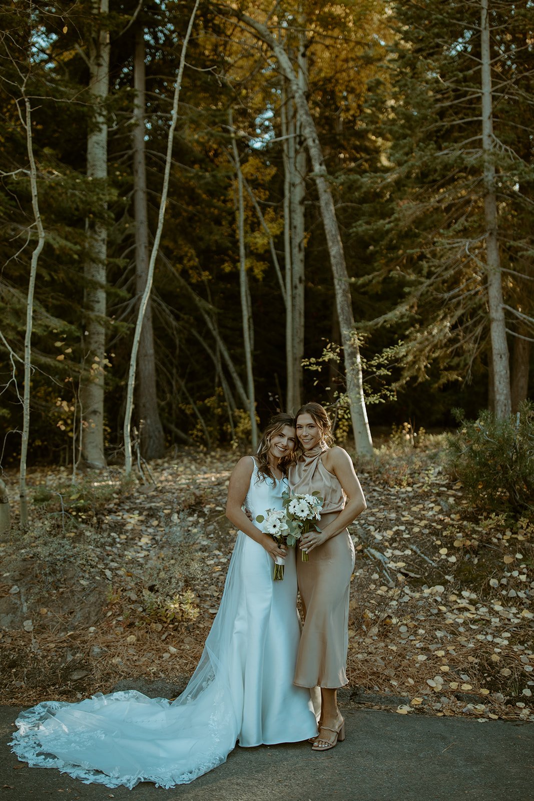 Emily and a bridesmaid in tan satin with her long train