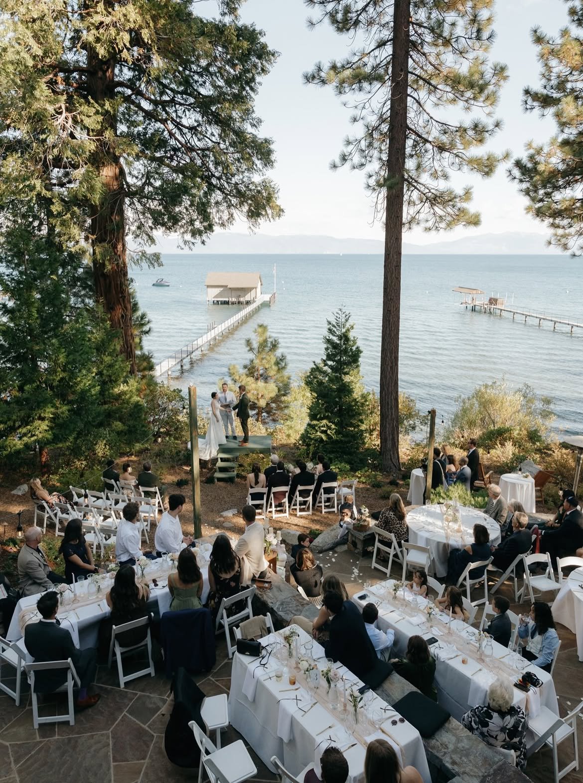 Looking down through the pines at the dinner tables on the stone terrace and the ceremony at the edge of Lake Tahoe