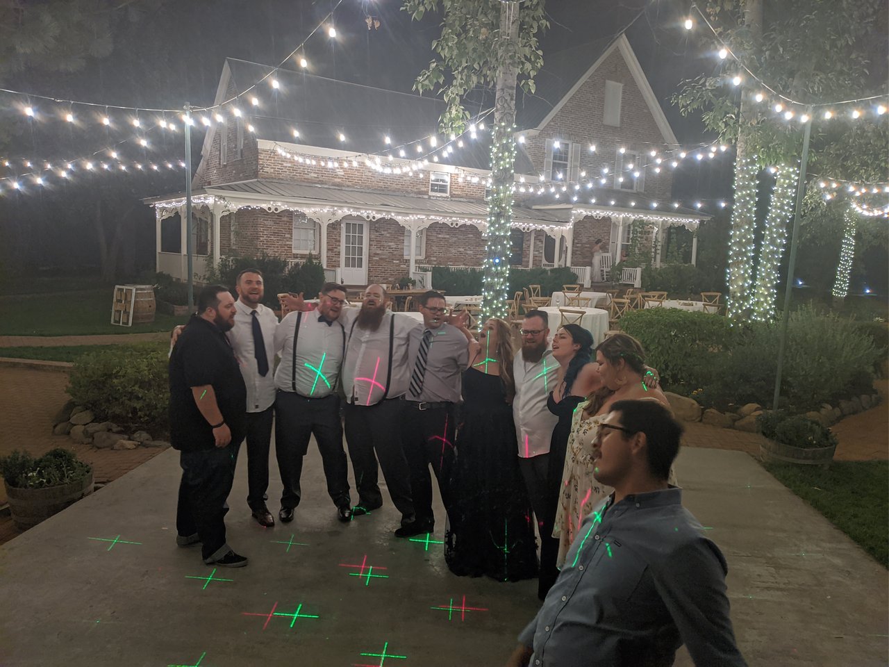 Guests arm in arm singing Bohemian Rhapsody under the string lights at Twenty Mile House