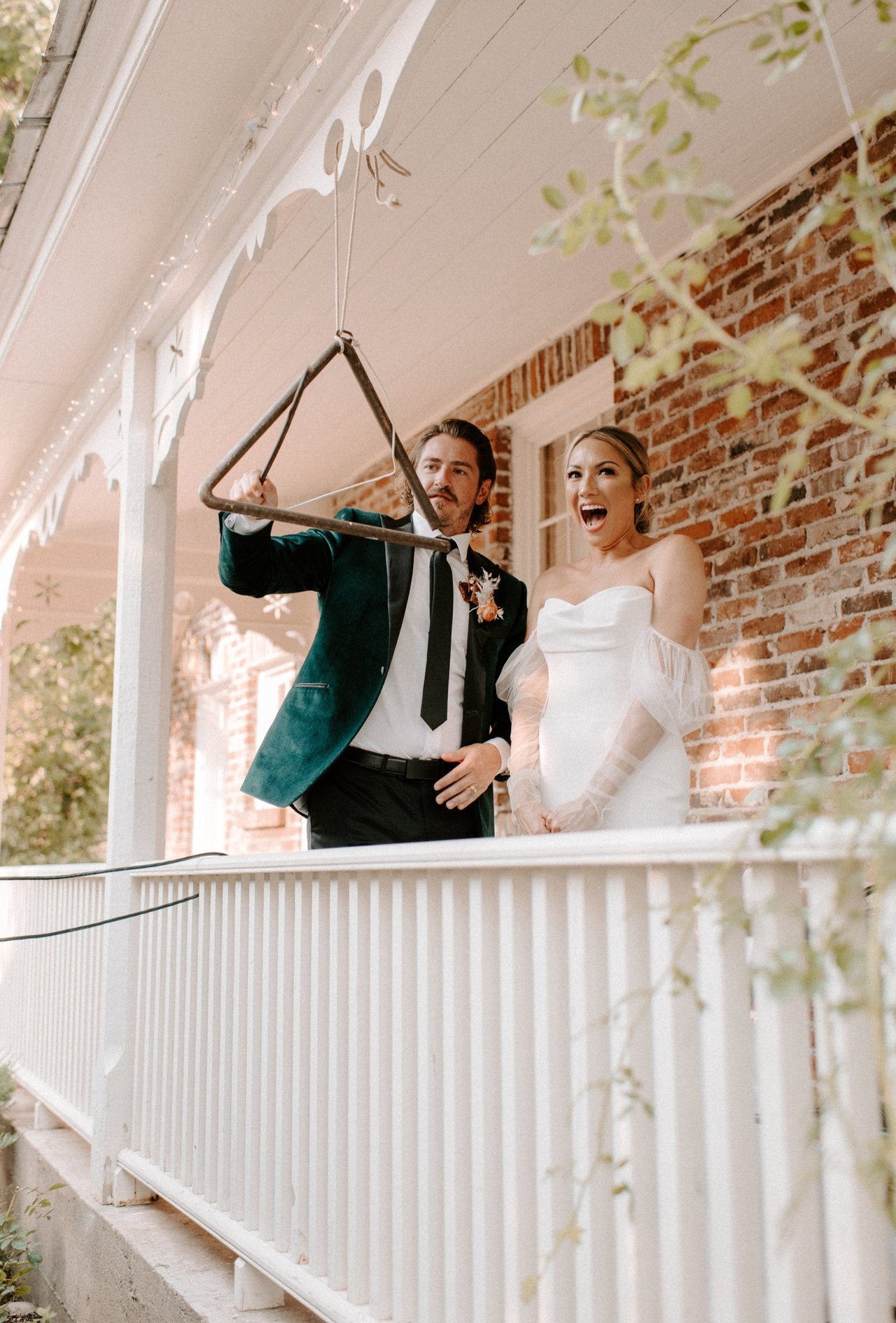 Joan and Kyle ring the dinner bell on the farmhouse porch