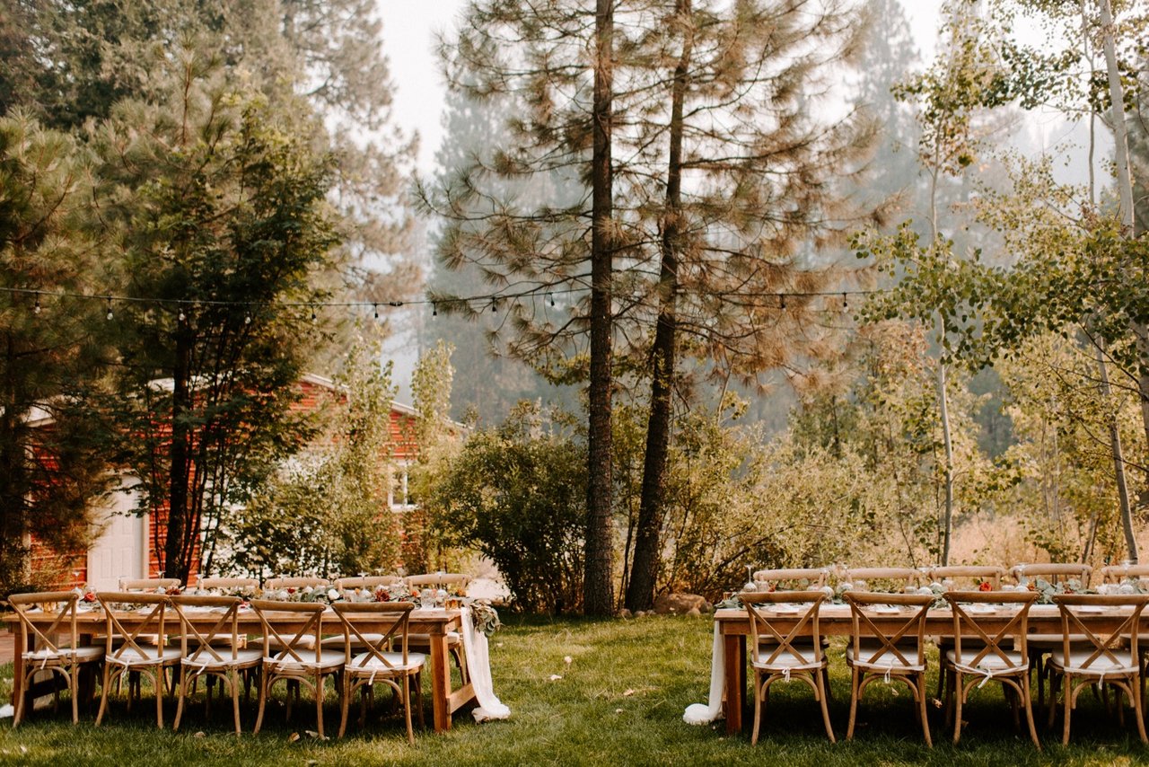 Reception tables set on the lawn beside the farmhouse