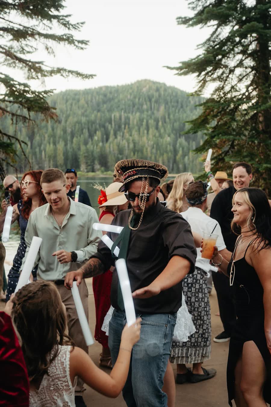 Guests dance with glow sticks beside the lake at Kaitlyn and Tristan's wedding reception