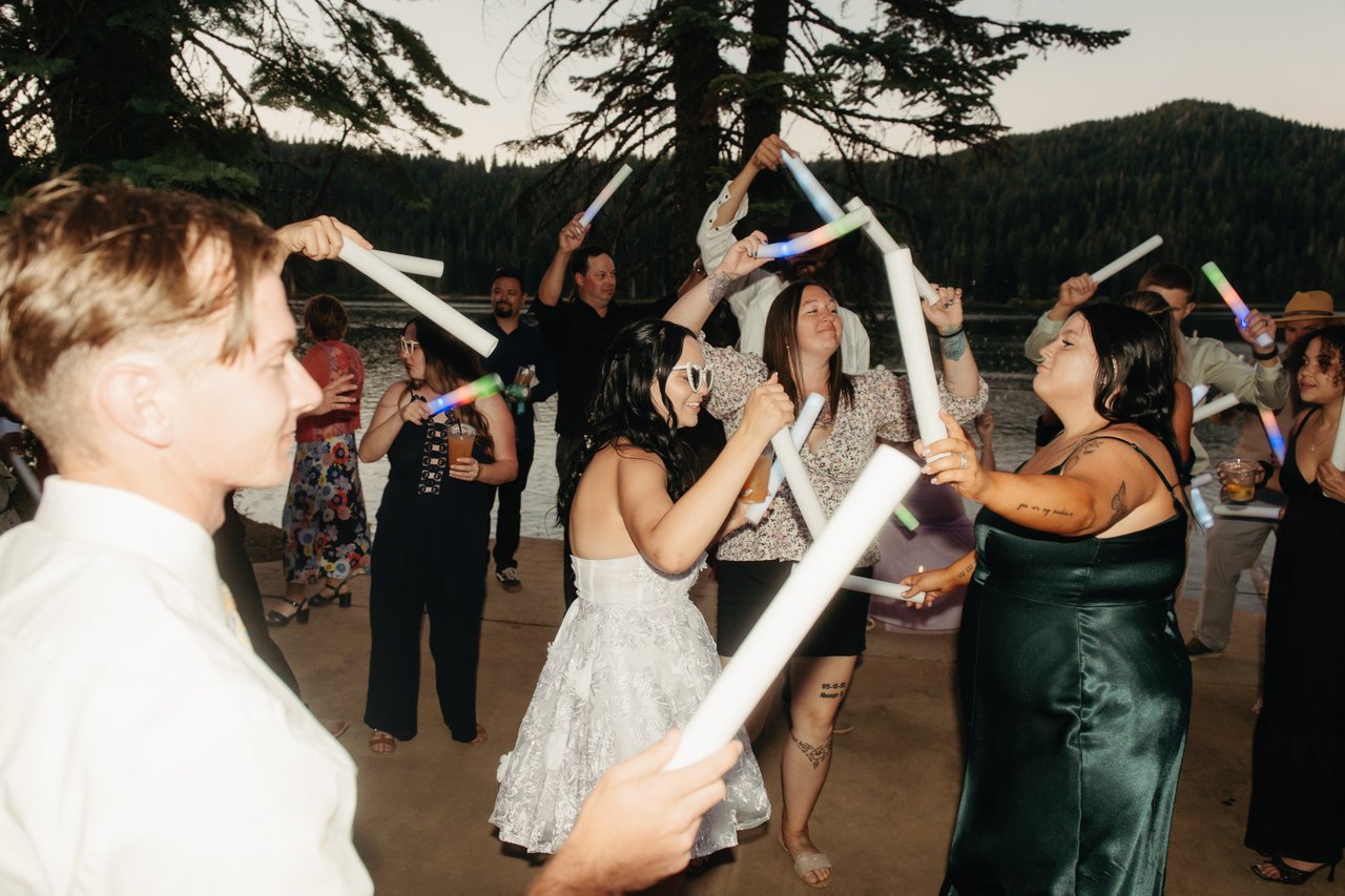 Kaitlyn and her friends cross foam batons as the light fades over Bucks Lake