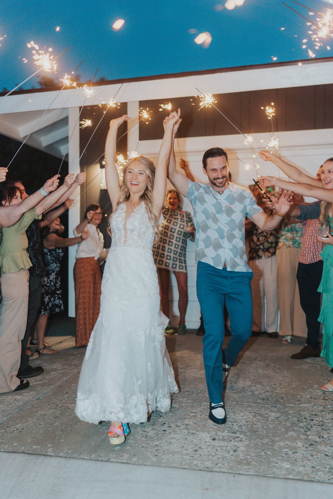 Lexy and Jeremy run through a tunnel of sparklers