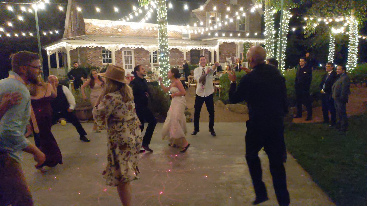 The bride dancing with guests under the string lights at Twenty Mile House