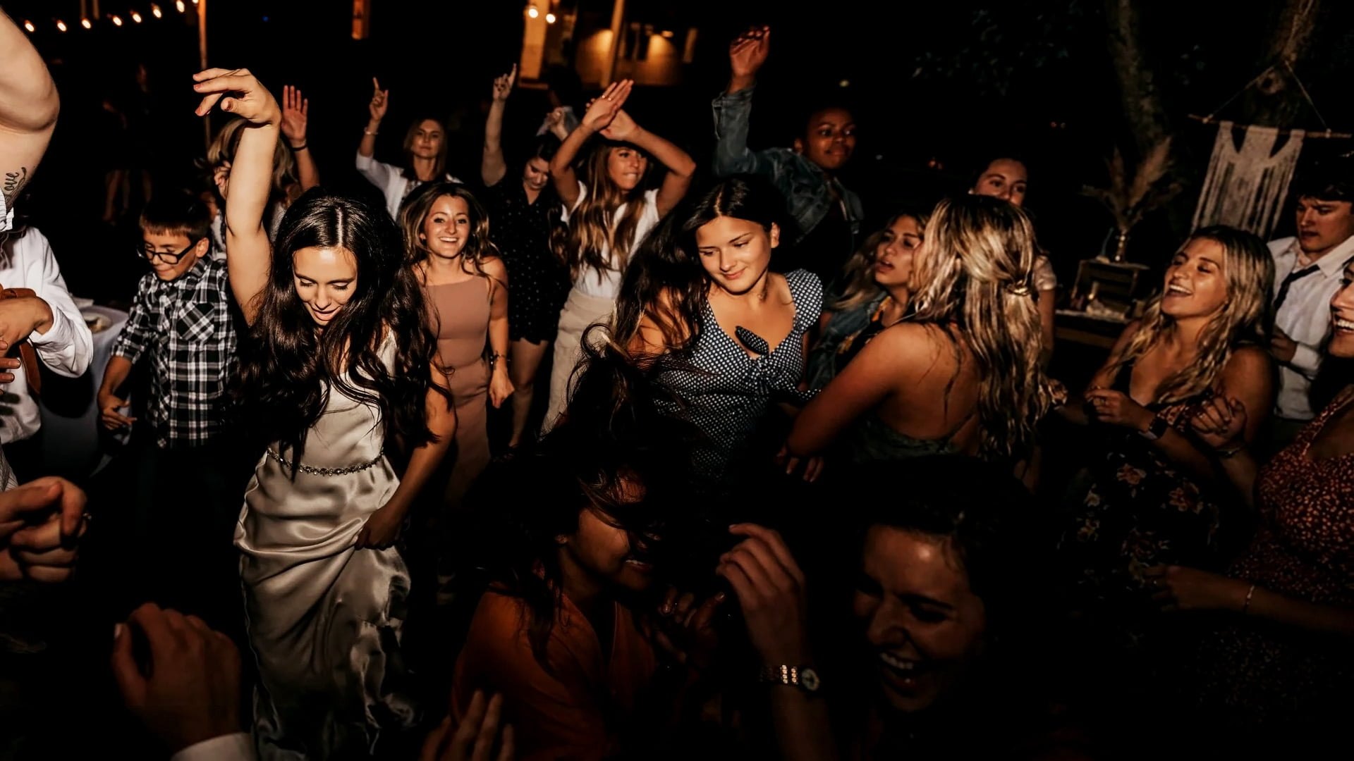 A packed dance floor at Lindsey and Nathanael's reception at Twenty Mile House, with Lindsey dancing among her friends