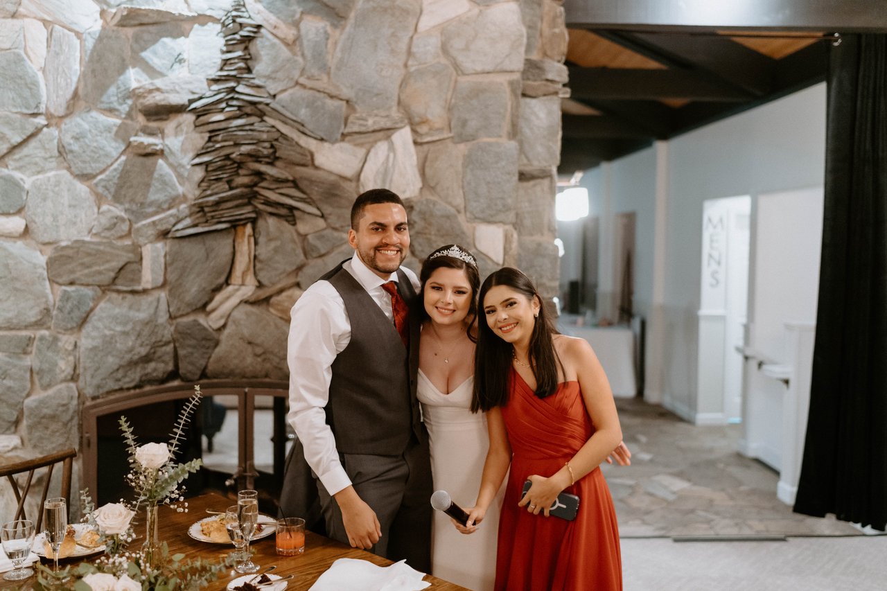 Jason and Montse pose with the maid of honor by the fireplace
