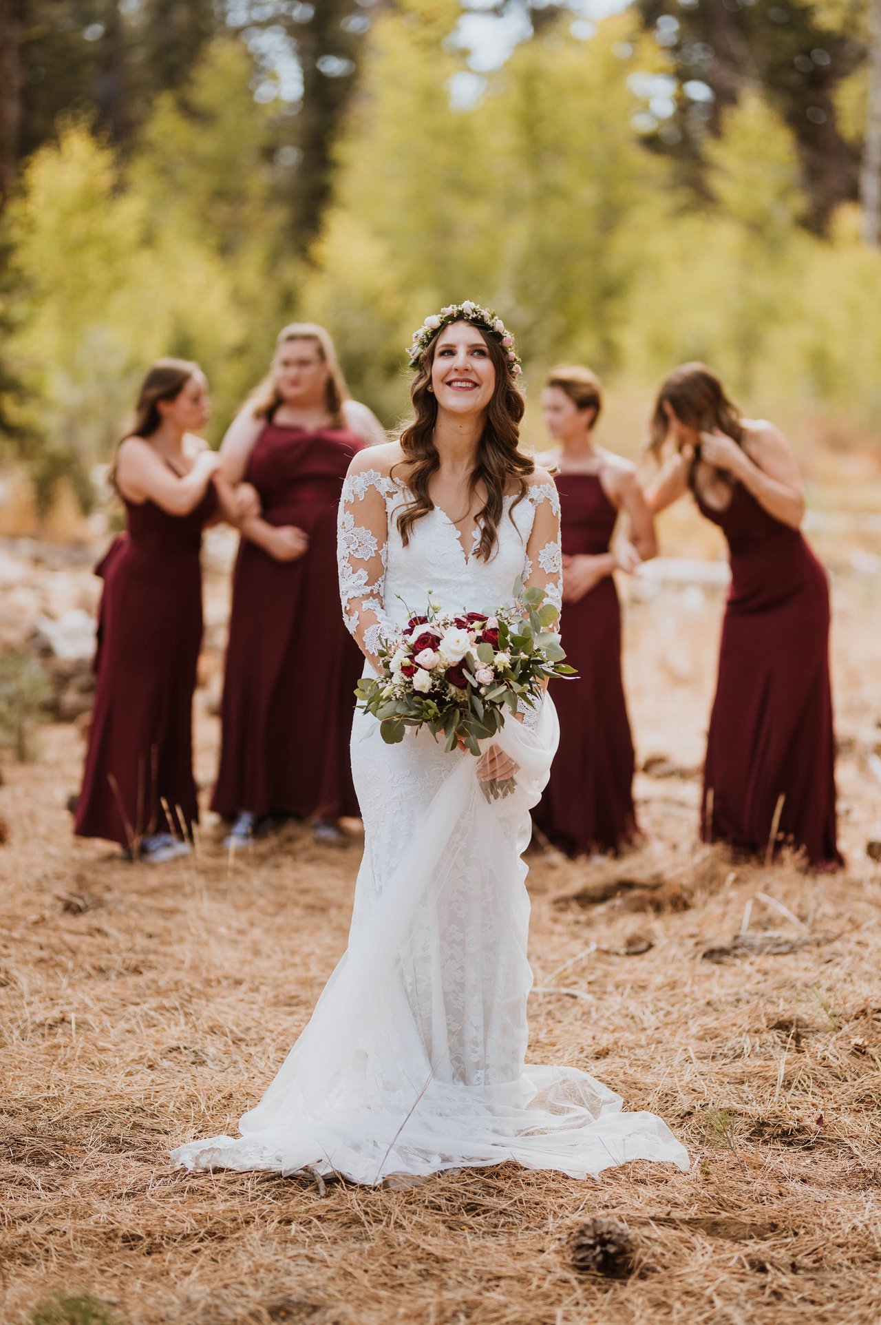 Rachel with her bridesmaids in burgundy among the pines