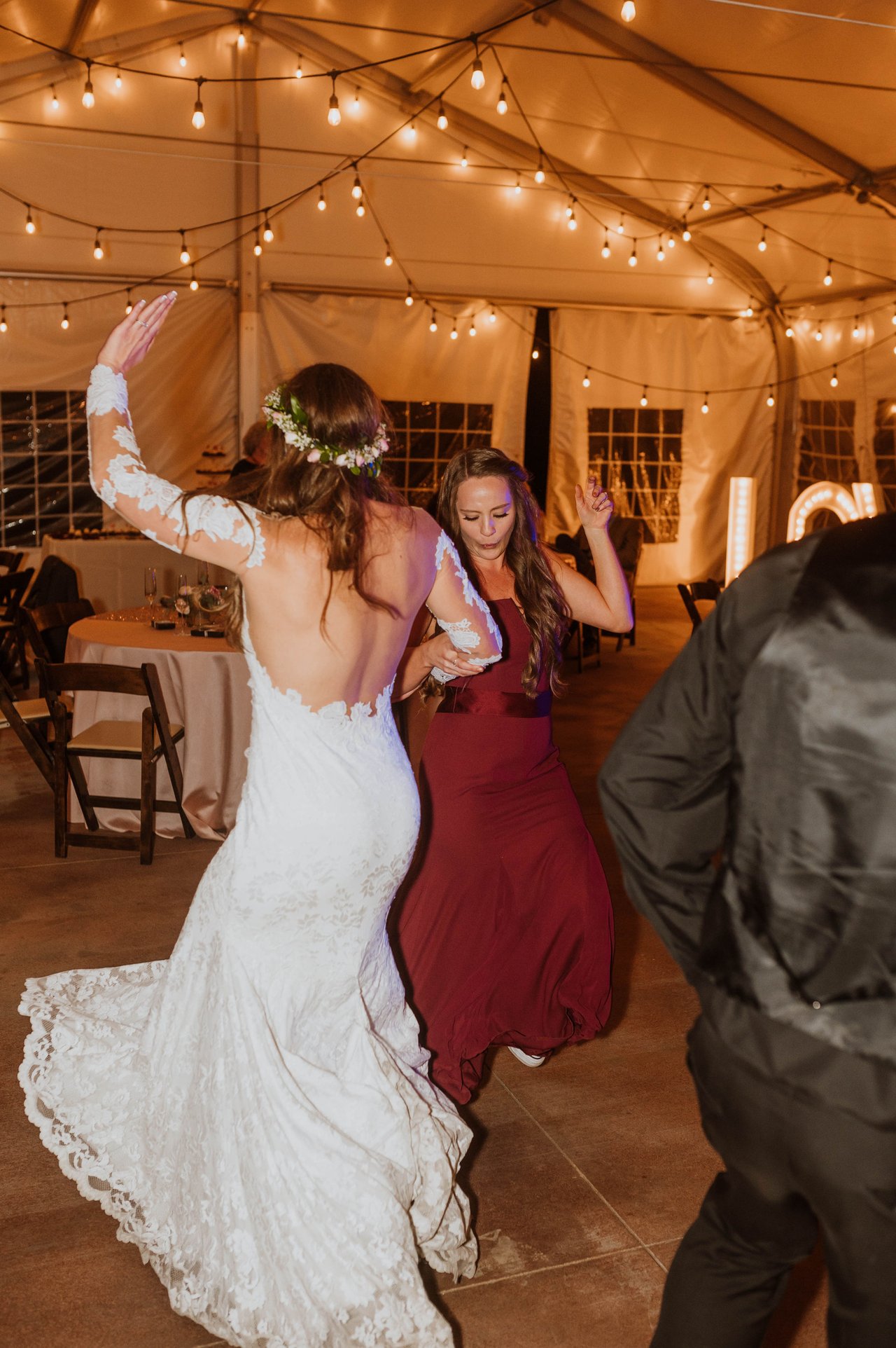 Rachel dances with her arm up beside her bridesmaid
