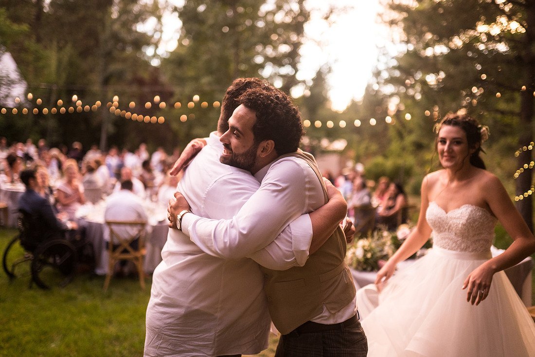 Ryan hugs a guest after a toast while Shannon smiles beside them