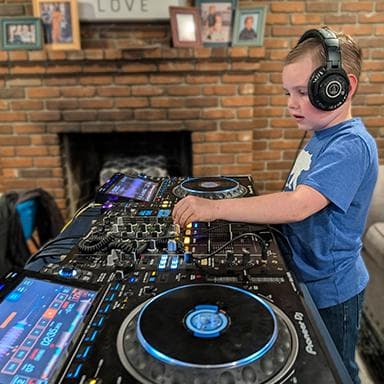 Student learning DJ techniques with professional equipment